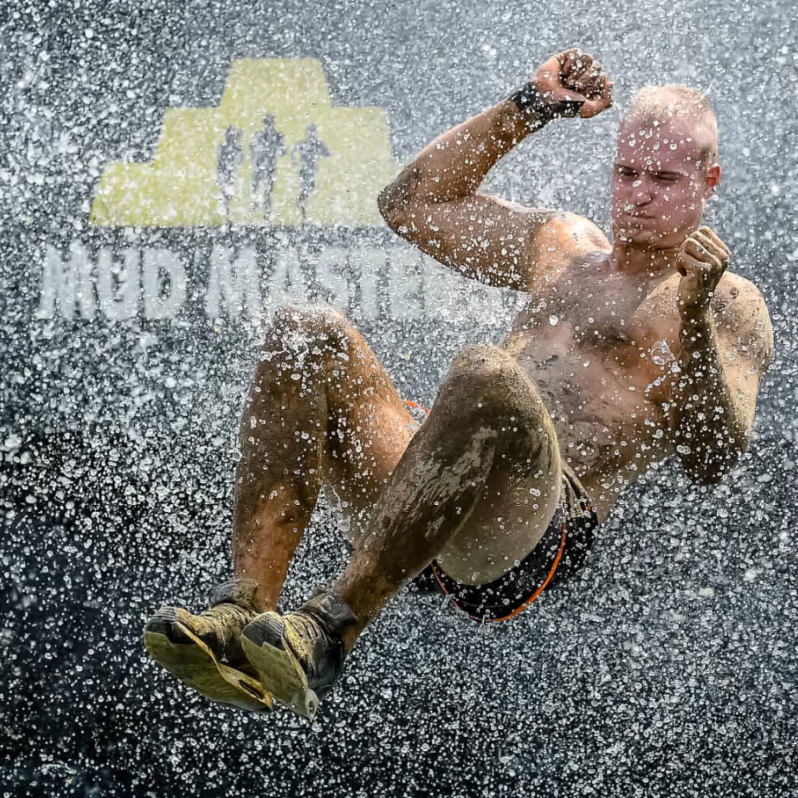Deelnemer komt door het water bij een obstakel tijdens Mud Masters
